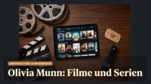 Filmrollen, Filmklappe und Tablet mit Streaming-Angebot auf einem Holztisch, daneben eine Kinokarte